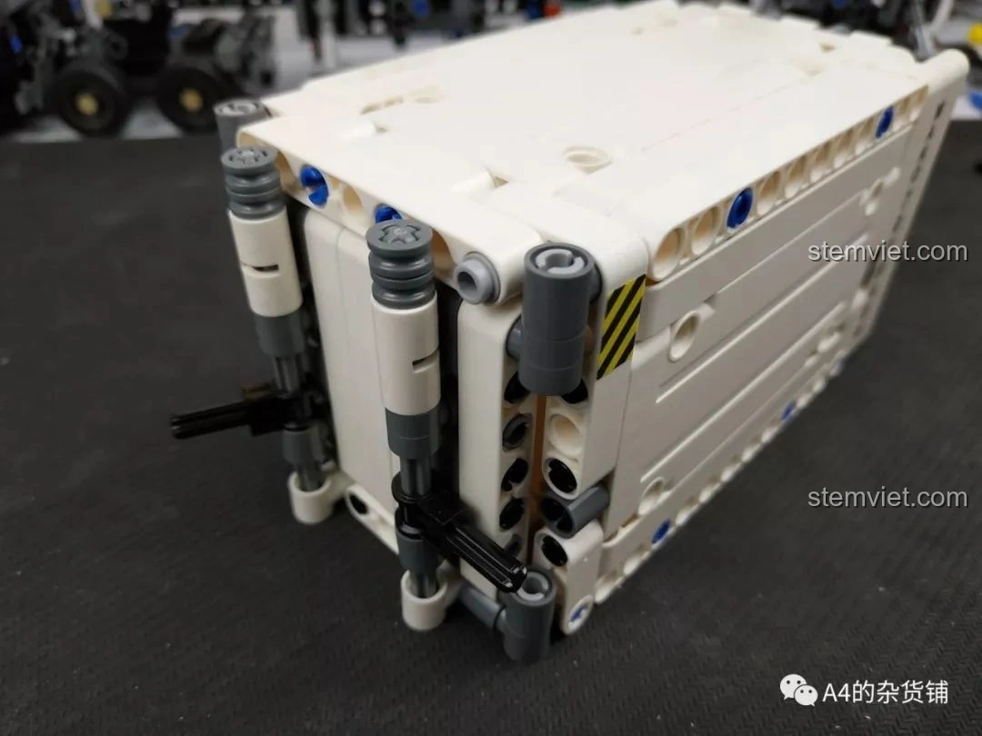 Chi tiết cửa khóa của container màu trắng, với các chốt màu đen, của bộ lắp ráp Xe Tải Container Cơ Khí SEMBO 703940.