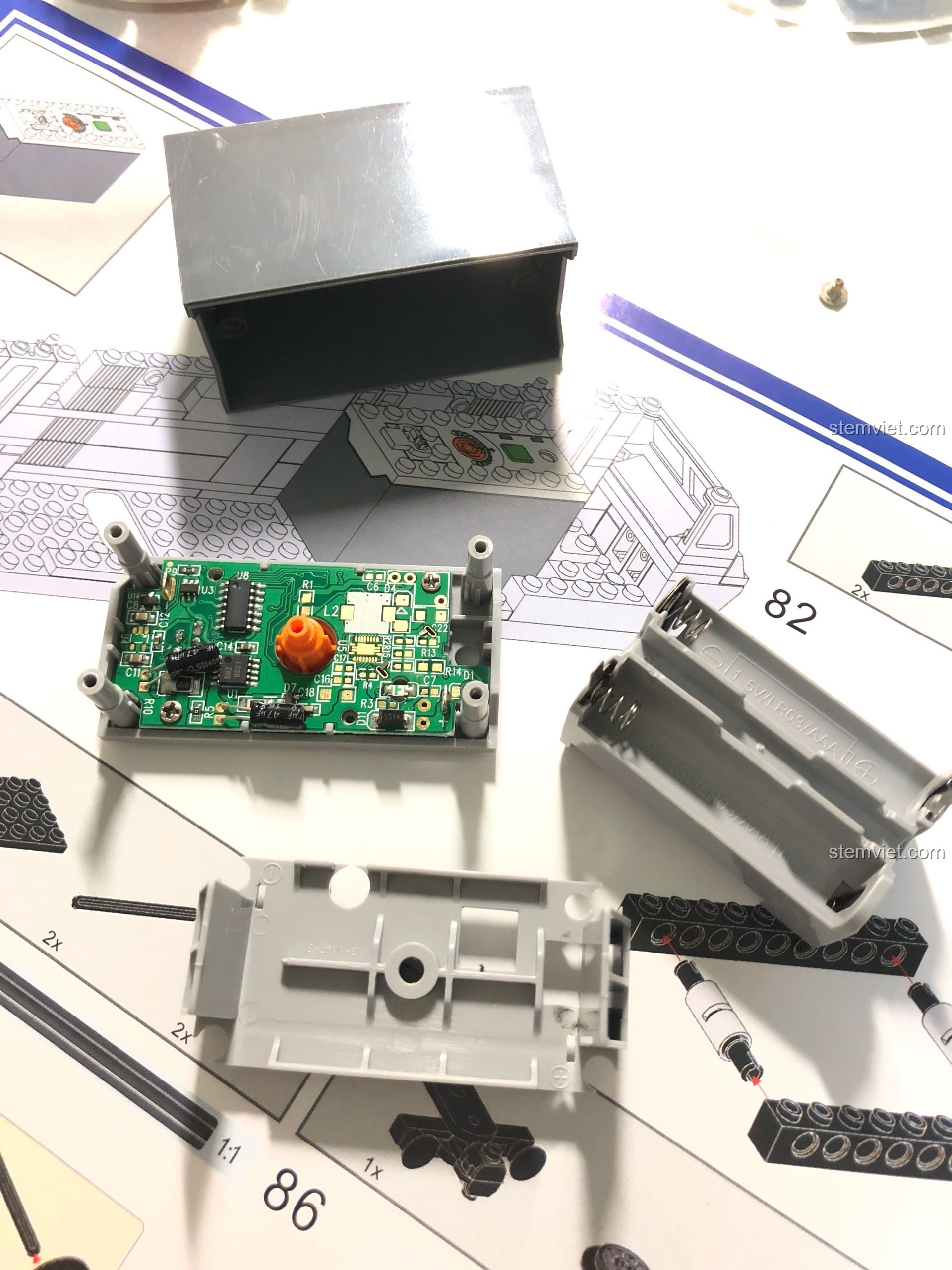 Cận cảnh chi tiết bên trong hộp pin của bộ lắp ráp KAZI 98220 Tàu Hỏa Đông Phong 11Z, cho thấy mạch điện tử.