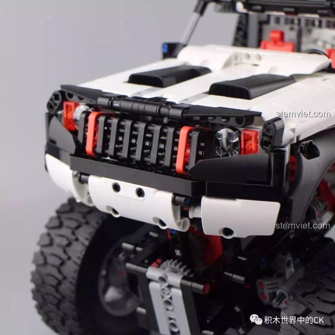 Cận cảnh lưới tản nhiệt và đèn pha của bộ đồ chơi mô hình Xe địa 4 bánh YYSQC01IQI, với các chi tiết màu đỏ làm điểm nhấn.