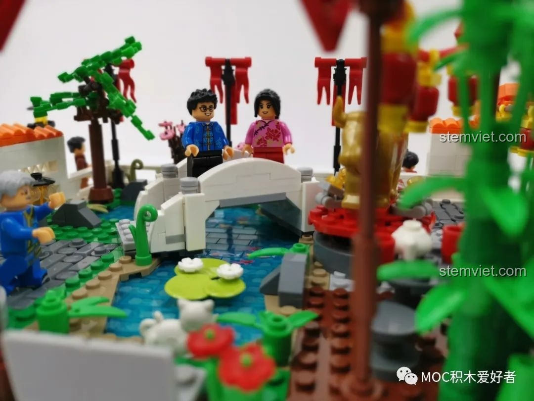 Hai nhân vật minifigure trẻ em đang trò chuyện trong bộ đồ chơi xây dựng Khung cảnh du xuân WOMA tiết kiệm.