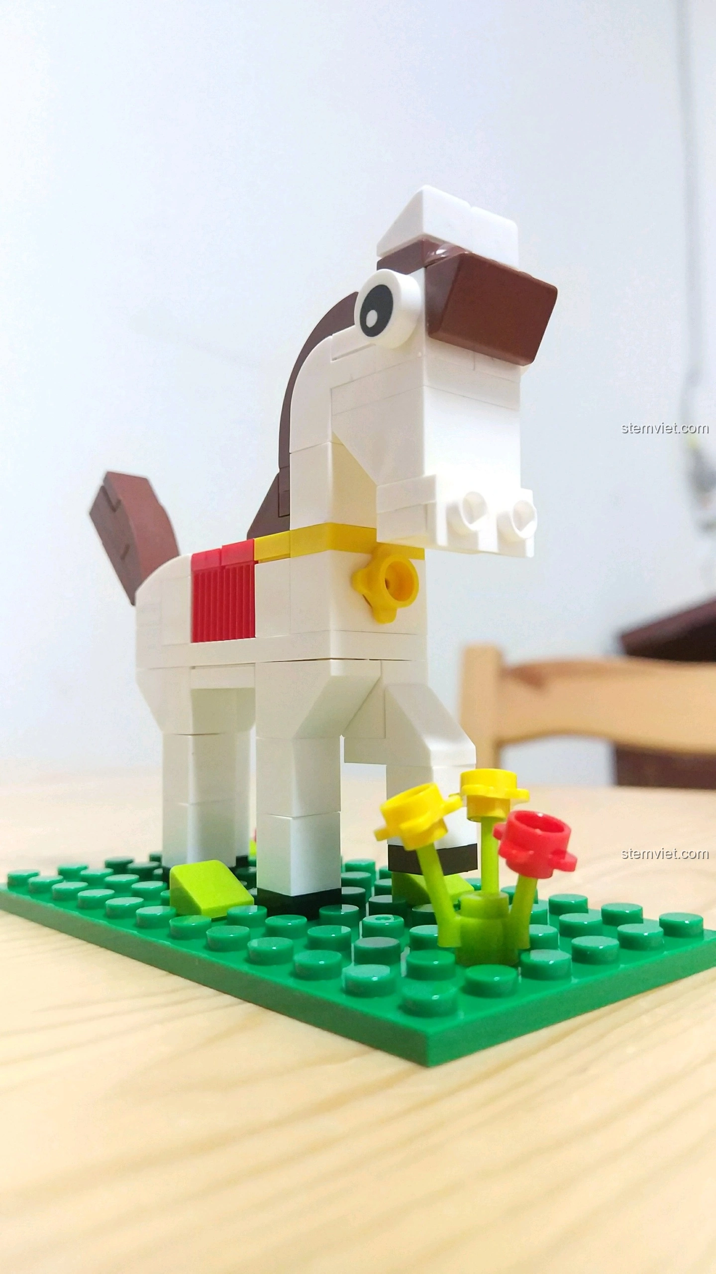 Mô hình Ngựa Ngọ nhìn từ góc thấp, cho thấy chi tiết khuôn mặt với đôi mắt to và lỗ mũi lớn, đứng trên nền cỏ xanh.