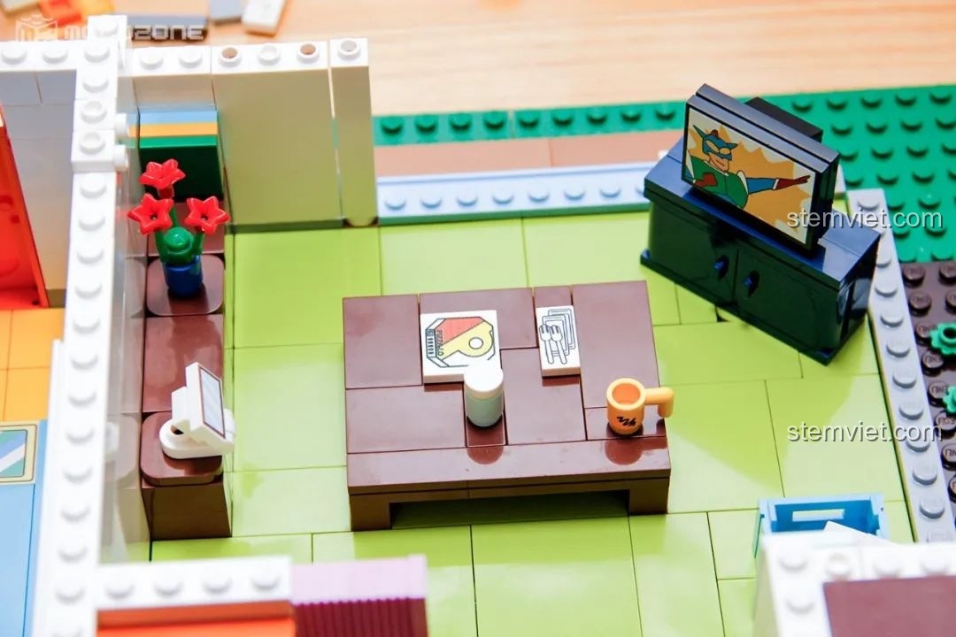 Cận cảnh phòng khách với TV đang chiếu siêu nhân Action Kamen, một chi tiết easter egg dành cho fan của Crayon Shin-chan.