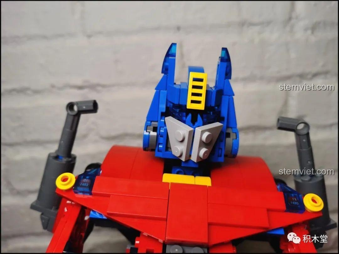 Robot Optimus Prime 15036 của Mould King đang tạo dáng với hai tay giơ lên, thể hiện khả năng cử động.