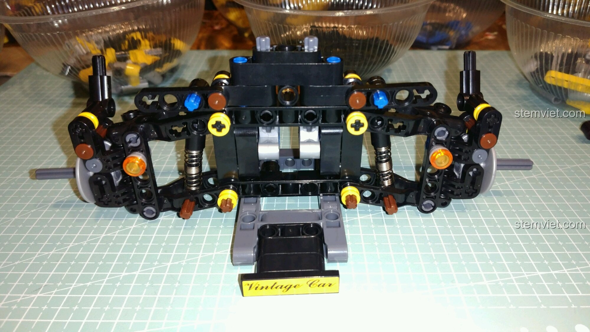 Khung gầm phía trước của đồ chơi xây dựng Xe Đua Cổ Điển Ba Bánh Winner đang được lắp ráp.