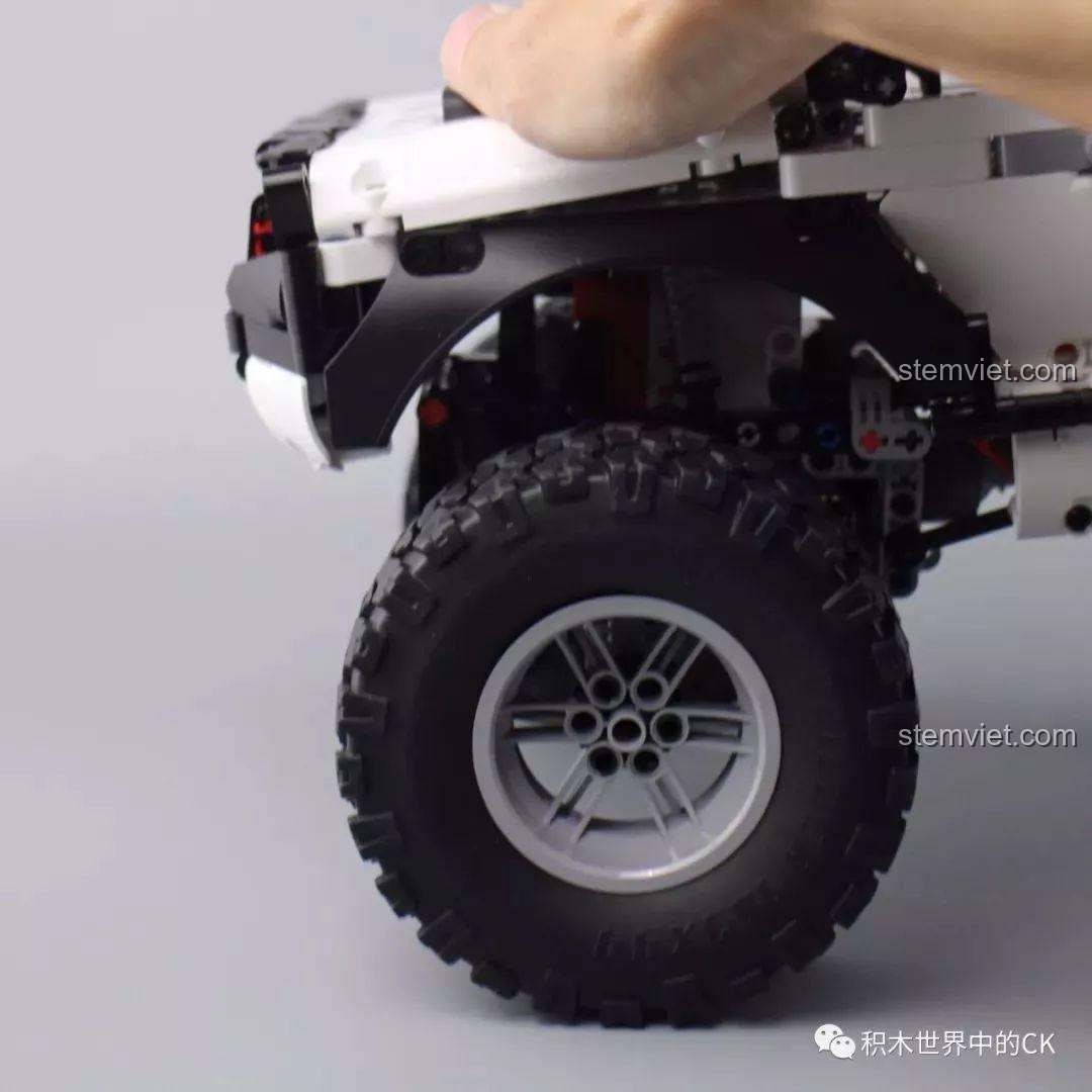 Một bàn tay đang nhấn xuống mui xe để kiểm tra độ đàn hồi của hệ thống treo trên Xe Địa Hình 4 Bánh Chủ Động Thông Minh.