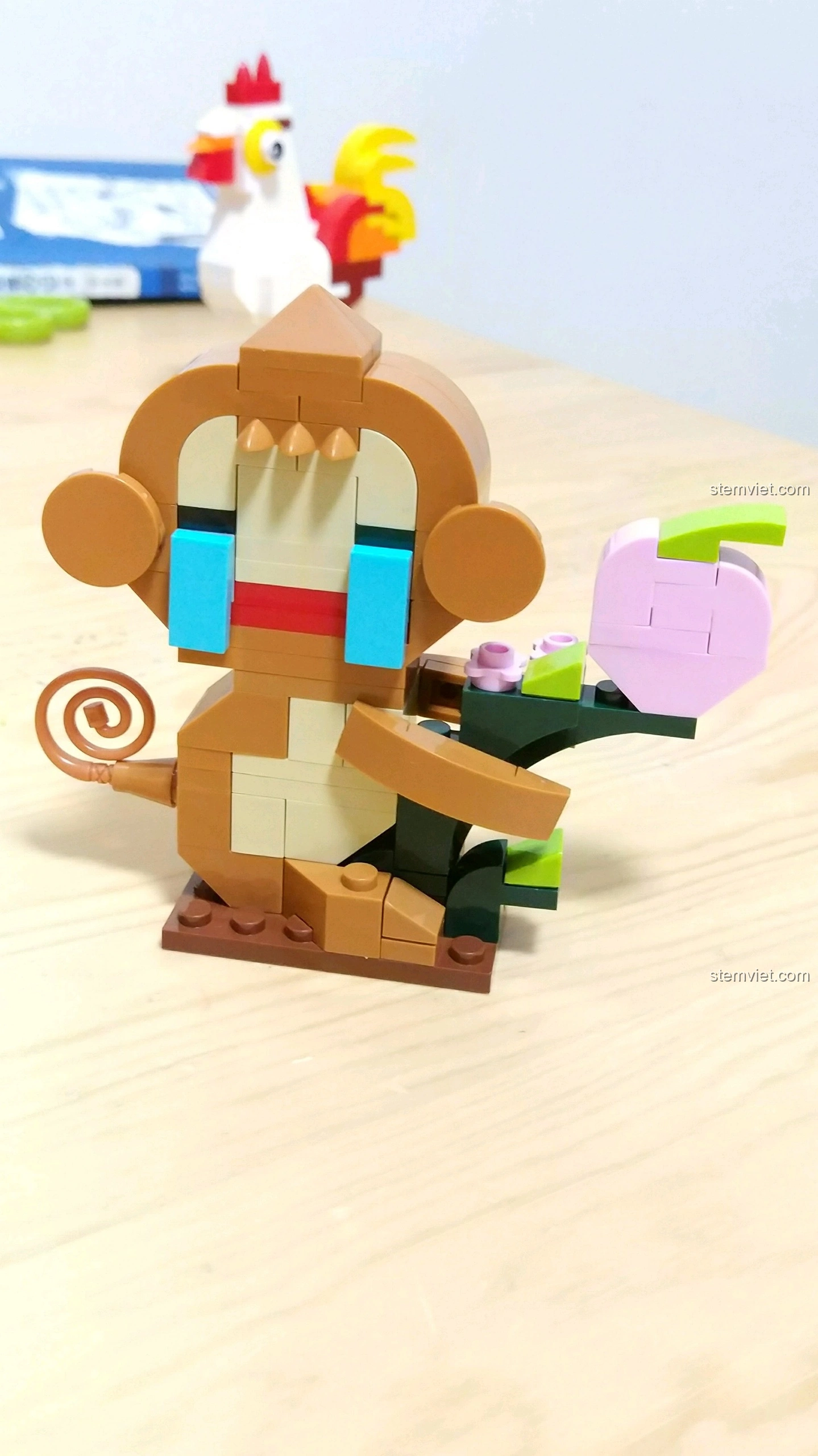 Mô hình Khỉ Thân với khuôn mặt buồn bã, mắt xanh, cầm quả đào hồng, từ bộ lắp ráp 12 Con Giáp XINGBAO XB-18001.