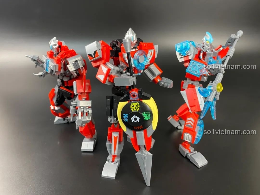 Đội hình ba mecha Ultraman (Geed, Orb, Ginga) đứng phía sau mecha Dada, nhìn từ góc ngang.