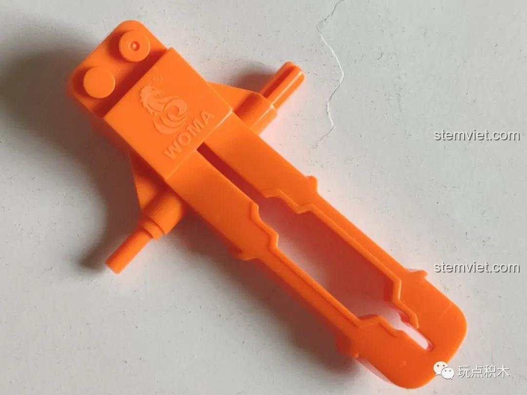 Dụng cụ tháo gạch màu cam đặc trưng đi kèm trong bộ đồ chơi mô hình Khủng long Triceratops WOMA C0451.