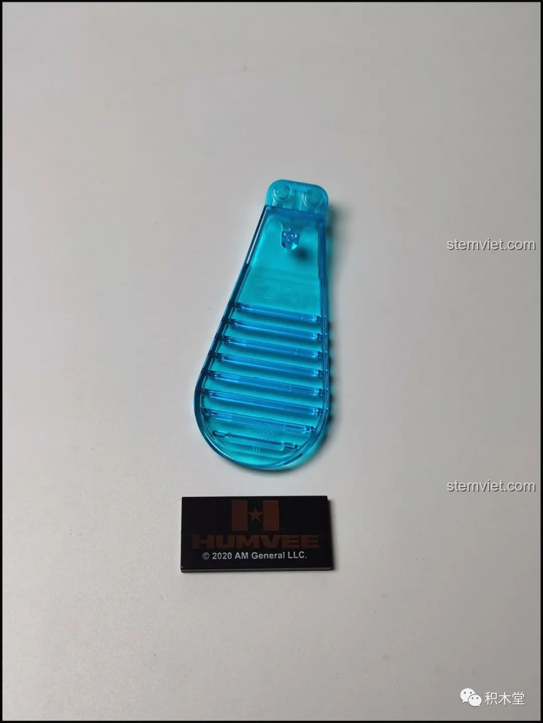 Dụng cụ tháo mảnh ghép màu xanh ngọc đặc trưng của CaDA và một mảnh ghép in logo Humvee bản quyền.