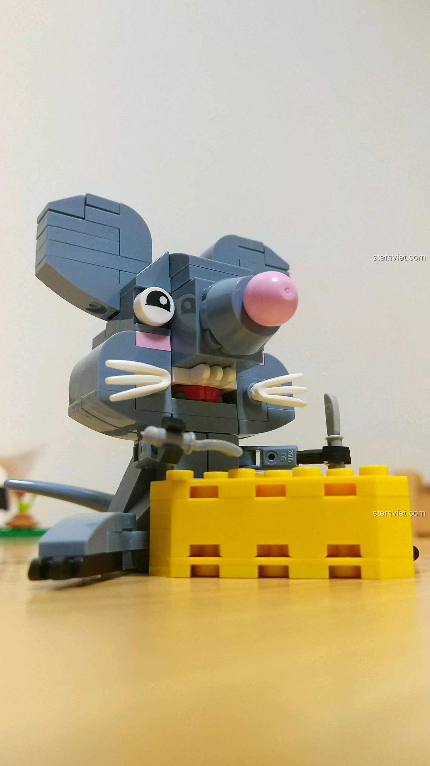 Mô hình Chuột Tý màu xám, cầm miếng phô mai vàng, với đôi tai to tròn và râu trắng, từ bộ lắp ráp 12 Con Giáp XINGBAO XB-18001.