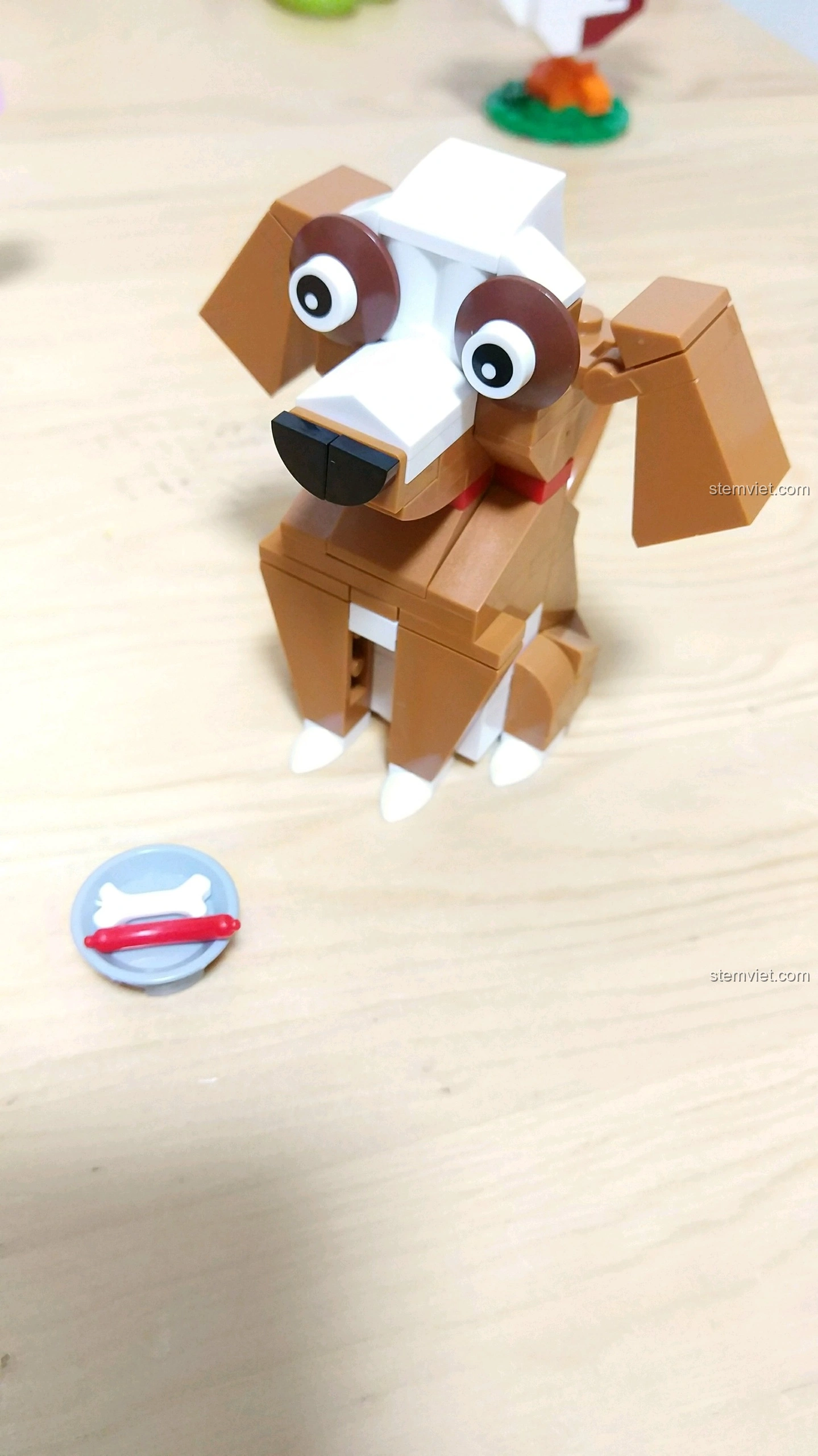 Góc nghiêng của mô hình Chó Tuất, cho thấy chi tiết tai dựng đứng và bát thức ăn với xương và xúc xích.