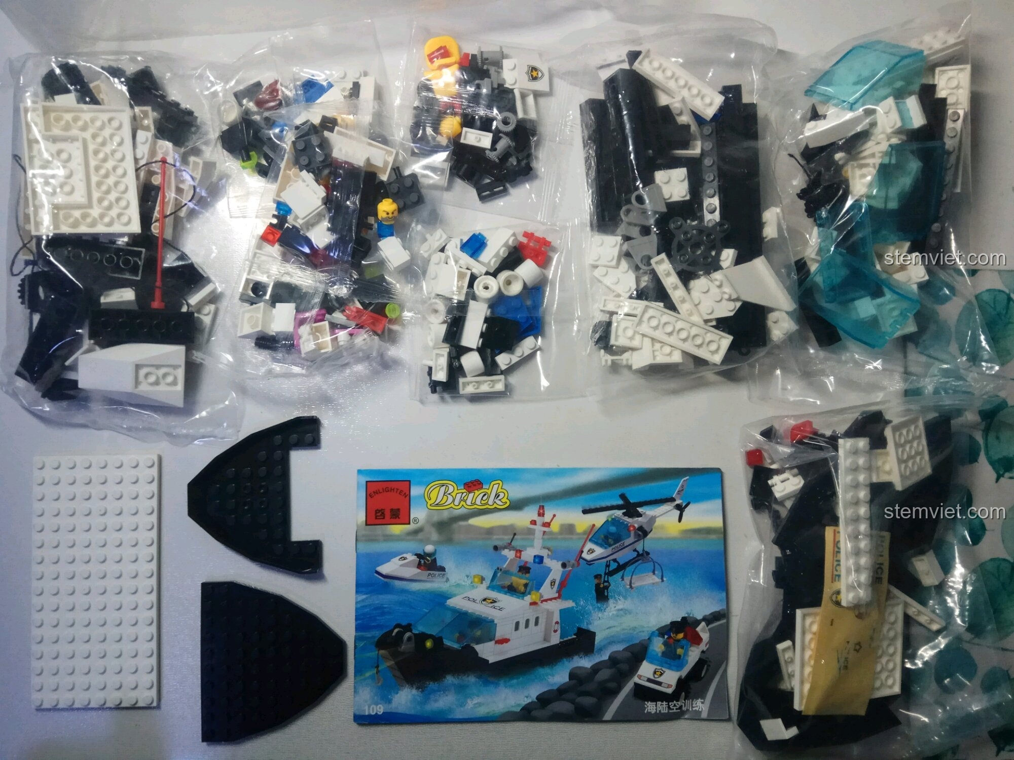 Bên trong hộp đồ chơi xếp hình Trực Thăng Cứu Hộ Cảnh Sát 109 với các túi chi tiết và sách hướng dẫn.