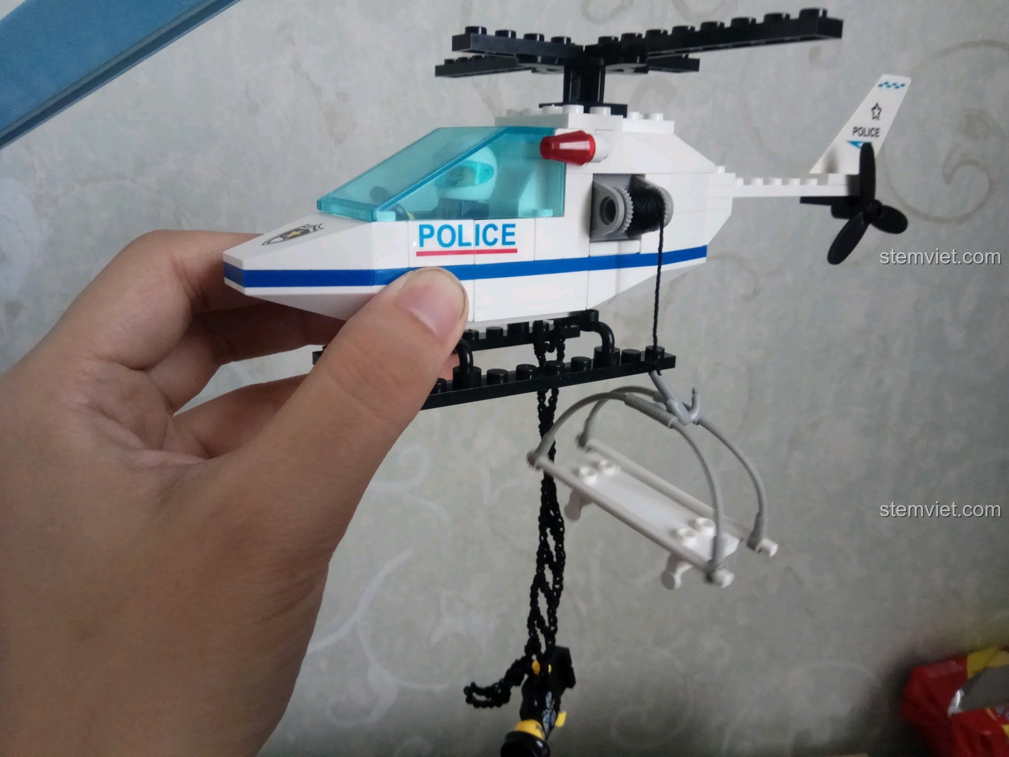 Tay người cầm mô hình trực thăng để thể hiện kích thước thực tế của sản phẩm.
