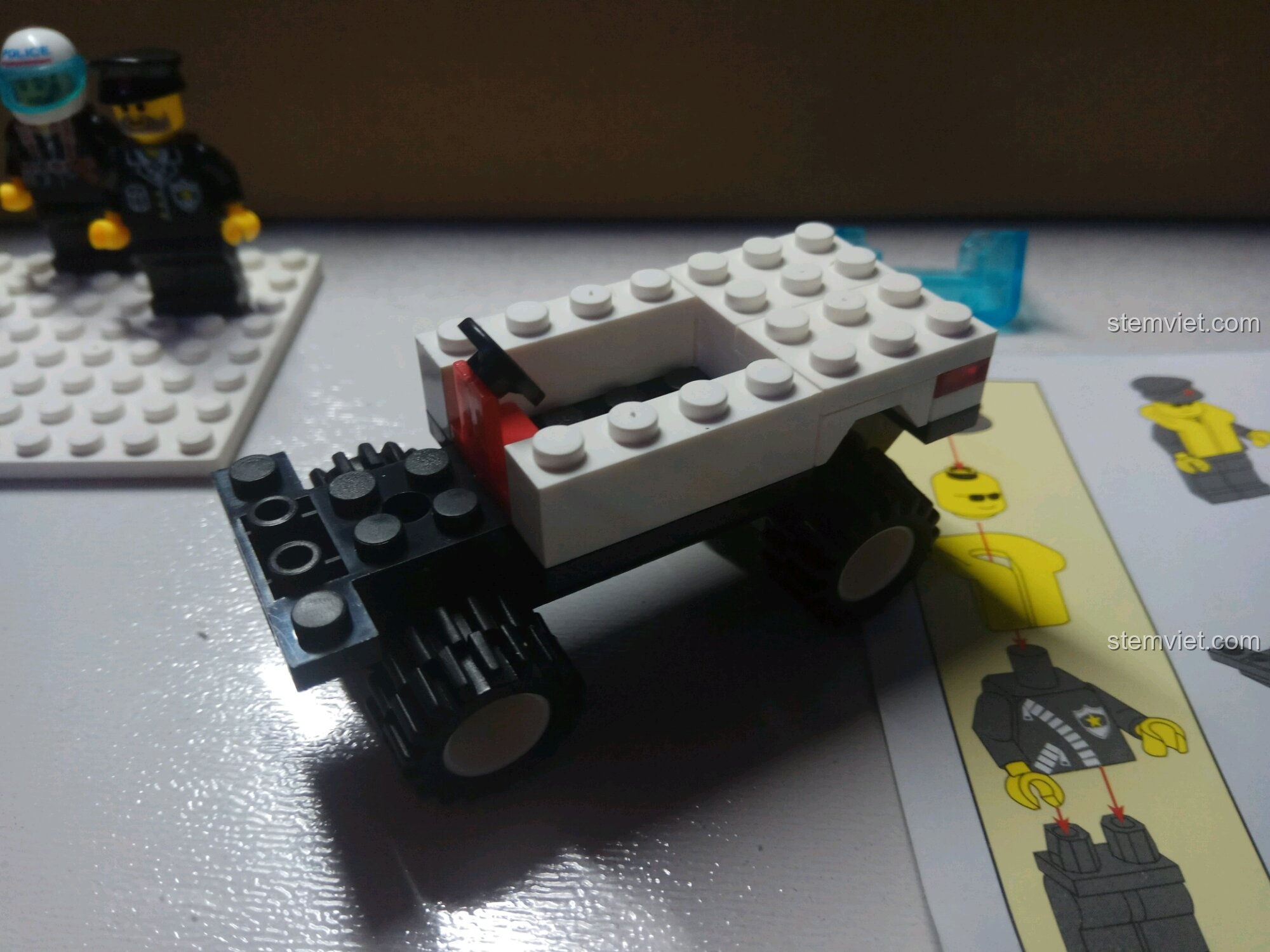 Hoàn thiện phần thân xe Jeep cảnh sát với ghế lái và các chi tiết trắng.