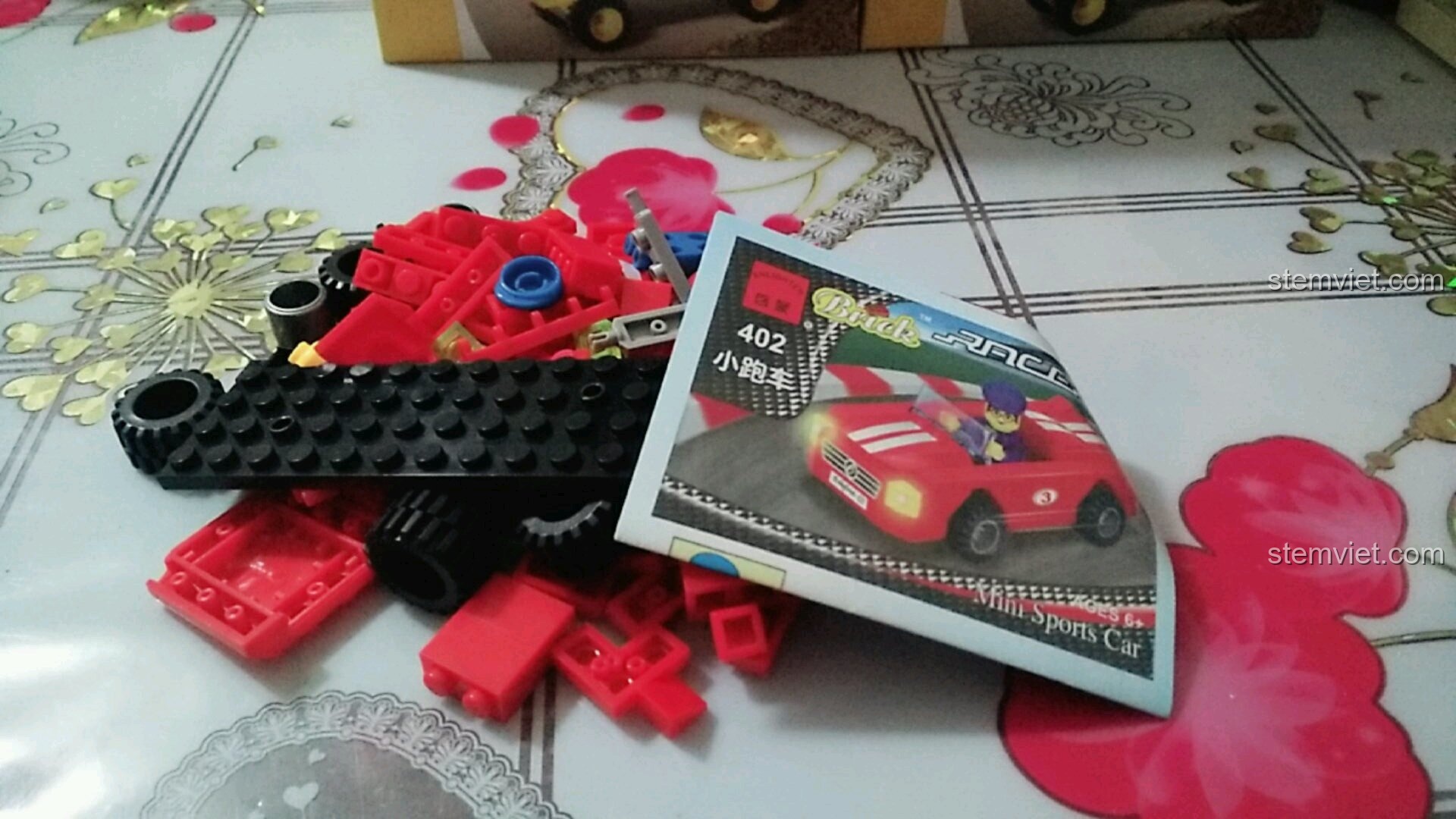 Các chi tiết và sách hướng dẫn của bộ đồ chơi Enlighten 402 được lấy ra khỏi hộp, sẵn sàng để lắp ráp.