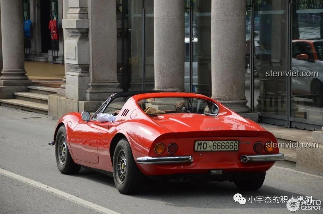 Hình ảnh chiếc Ferrari Dino 246 GTS màu đỏ ngoài đời thực đang di chuyển trên đường phố.