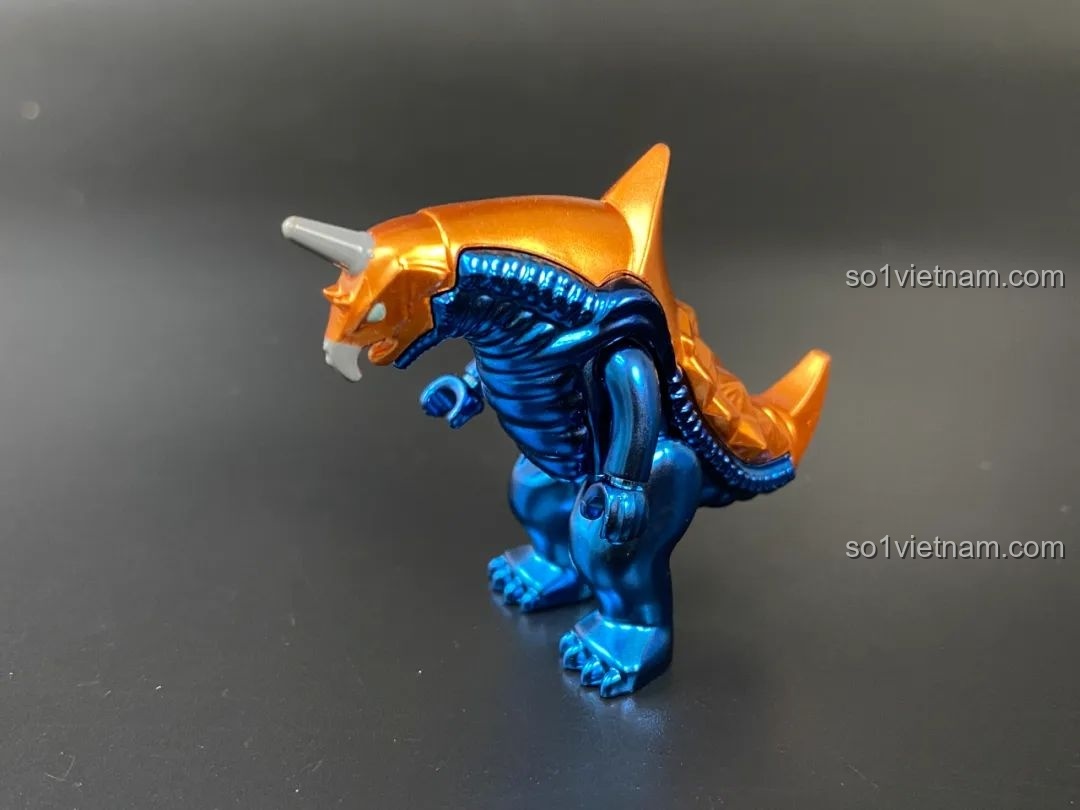 Figure quái vật Baragon với lớp sơn bóng màu xanh và cam.