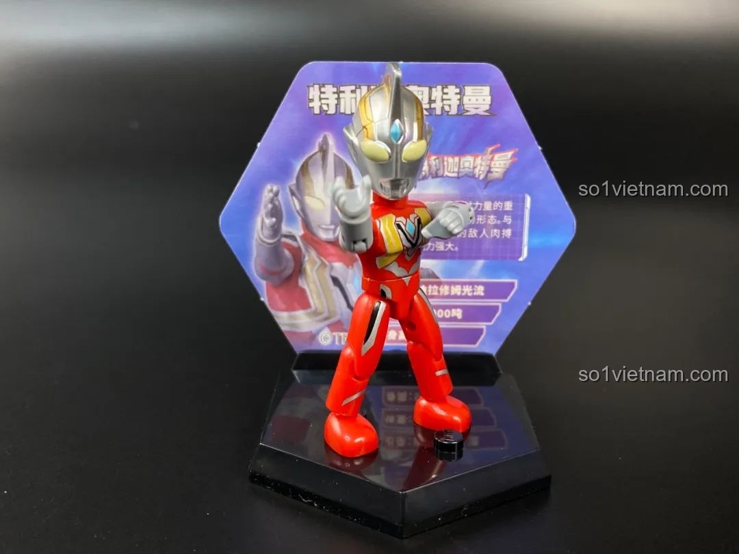 Figure Ultraman Ginga được đặt trên đế trưng bày hình lục giác với thẻ bài phía sau.