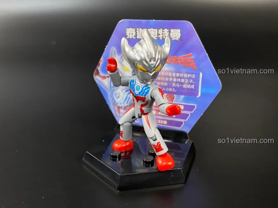 Figure Ultraman Titas được đặt trên đế trưng bày hình lục giác với thẻ bài phía sau.