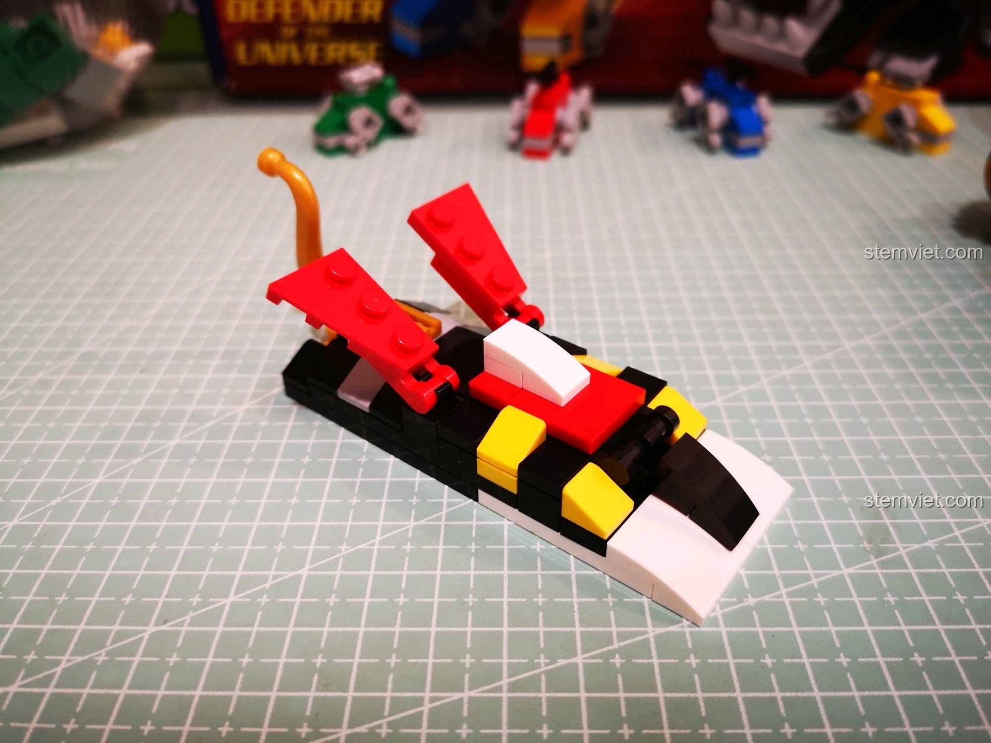 Gắn chi tiết cánh đỏ và đuôi vàng lên lưng mô hình Sư tử Đen.