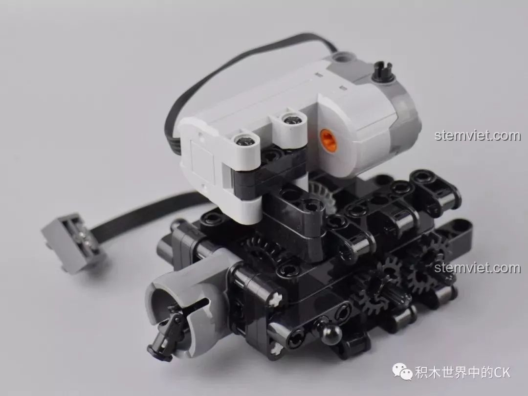 Gắn động cơ vào cụm truyền động của mô hình xe G65 Mould King 13070, các bánh răng đen bắt đầu xuất hiện.