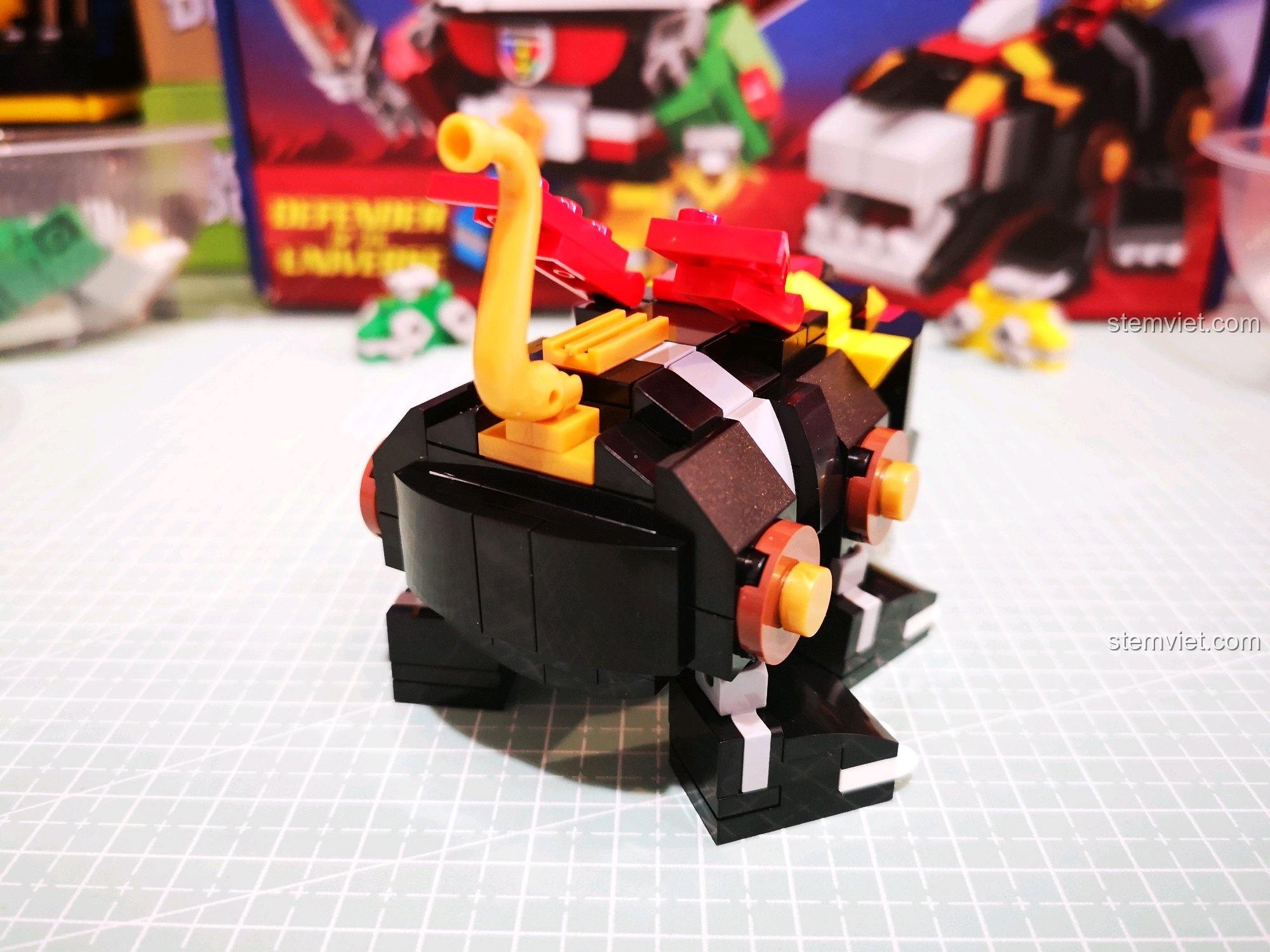 Góc nhìn từ phía sau của Sư tử Đen, khoe trọn chiếc đuôi vàng và đôi cánh đỏ nổi bật.