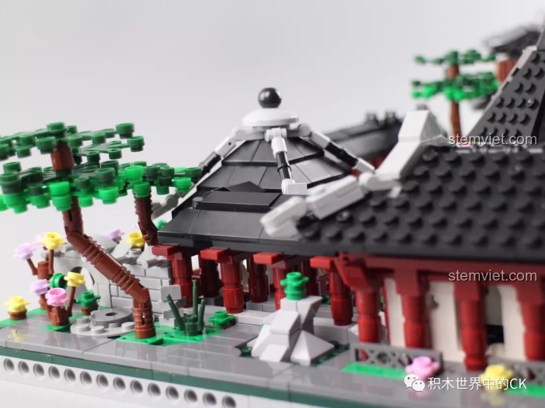 Ảnh chụp cận cảnh một góc sân vườn với cây, đá và mái đình trong bộ Vườn Tô Châu.