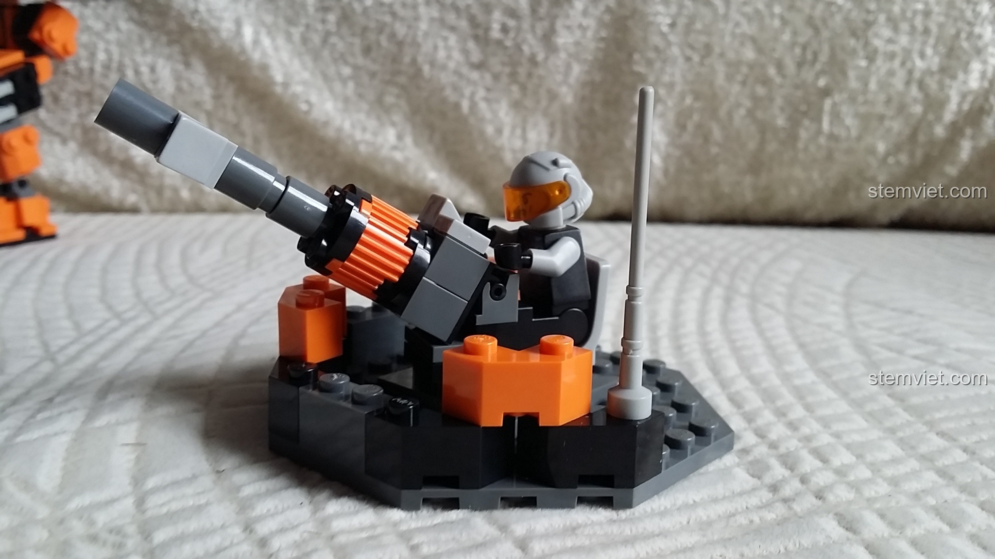 Robot GUDI 8224 SkyNet Bombard và khẩu pháo nhỏ đặt cạnh nhau, thể hiện sự kết hợp.