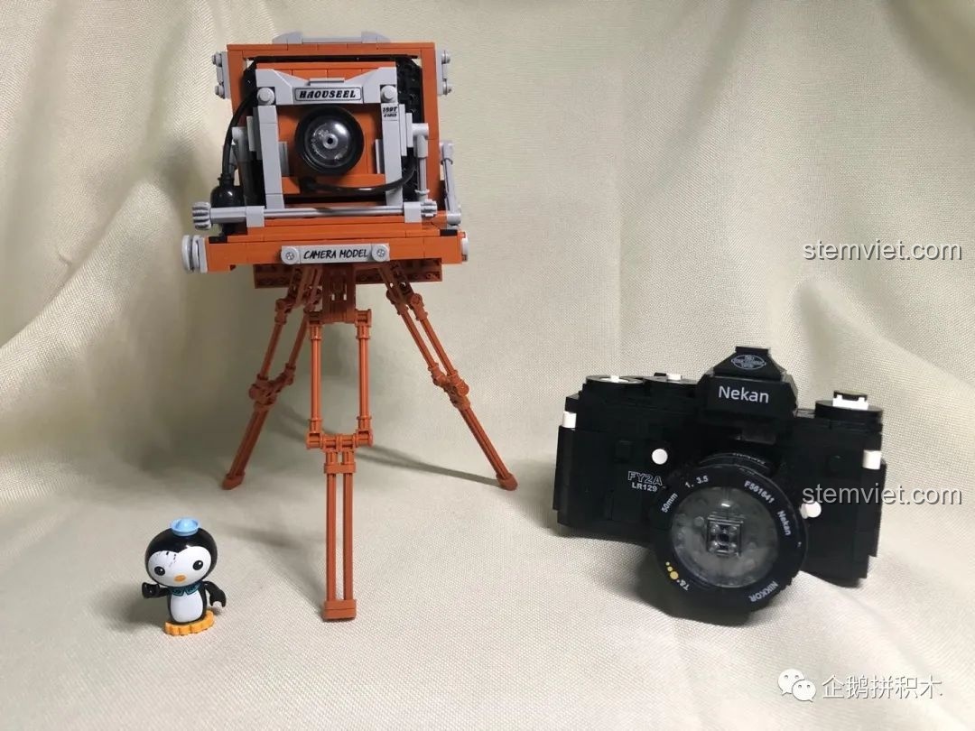 Hai mô hình máy ảnh lắp ráp, Máy Ảnh Kỹ Thuật Số Nekan FY2A LR129 (00844) và máy ảnh retro, cùng trưng bày.
