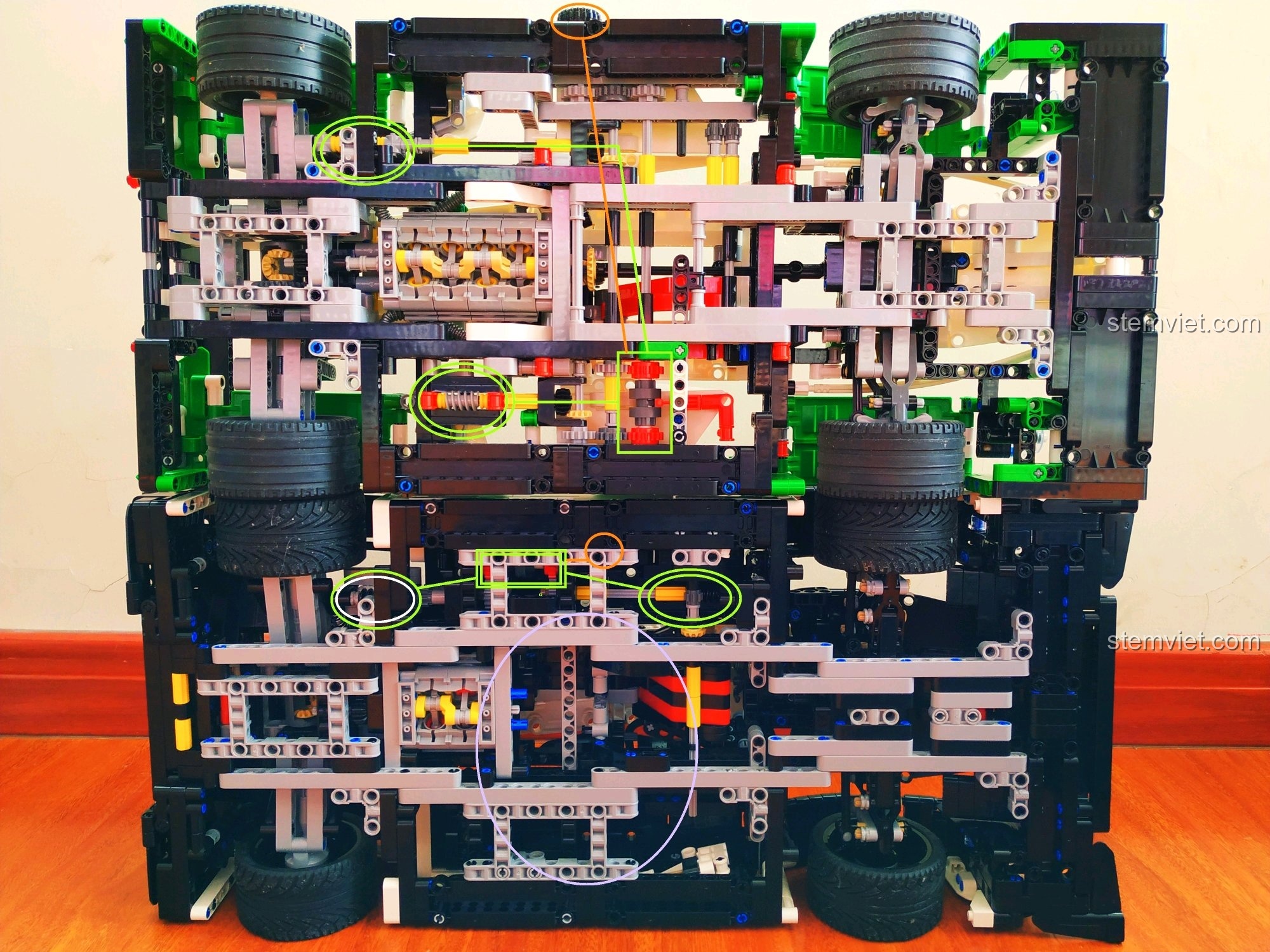 Nhìn từ dưới lên, cho thấy hệ thống treo, bánh xe và các chi tiết cơ khí phức tạp của xe đua Porsche 919 Hybrid.