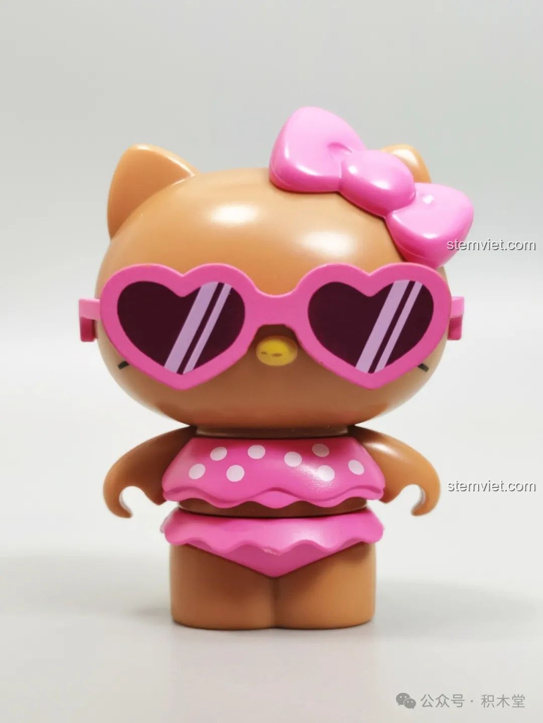 Mô hình Hello Kitty da nâu trong bộ bikini chấm bi hồng, đeo kính râm trái tim, một phần của bộ đồ chơi lắp ráp TOP TOY.