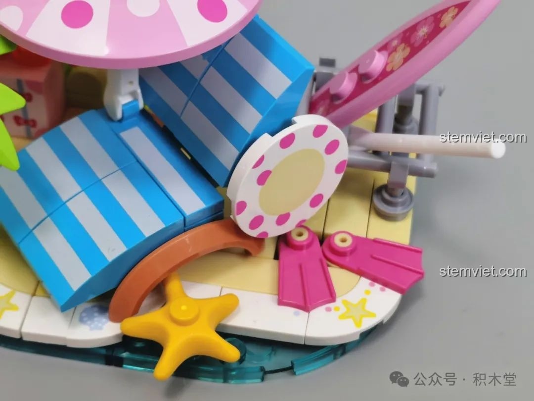 Cận cảnh các chi tiết của bộ Tắm Nắng Xinh Đẹp (TC2322) như ghế tắm nắng, ô che nắng, sao biển và ván lướt, tạo nên khung cảnh bãi biển sống động.