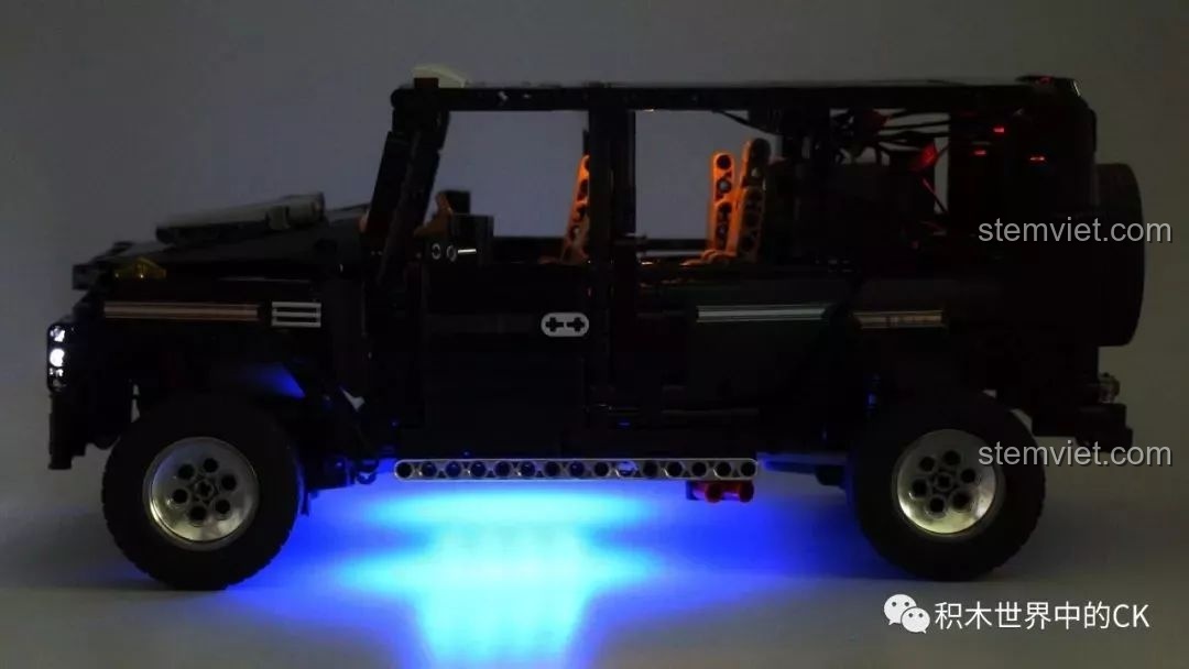 Góc nhìn từ phía sau của xe Mould King 13070 khi bật đèn, khoe đèn hậu và ánh sáng xanh từ gầm xe.
