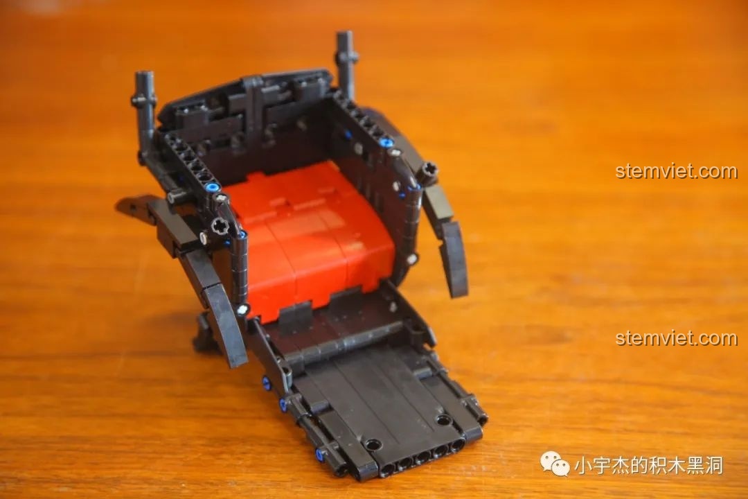 Mô hình xe kéo tay AchKo đang dần hoàn thiện phần thân xe và ghế ngồi màu đỏ nổi bật.