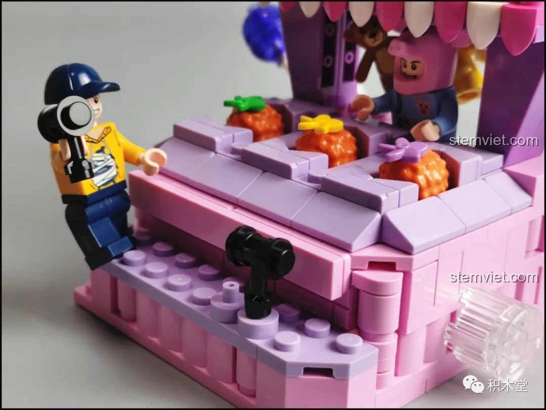 Hộp đựng tiền xu với hai đồng tiền vàng bên trong của bộ lắp ráp Pantasy Joyside 61004 cảnh quan công viên giải trí.