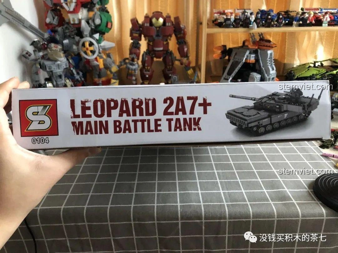 Hộp bộ lắp ráp Jiazhi 0104 Xe Tăng Leopard 2A7+ được cầm trên tay, cho thấy kích thước thực tế của sản phẩm.