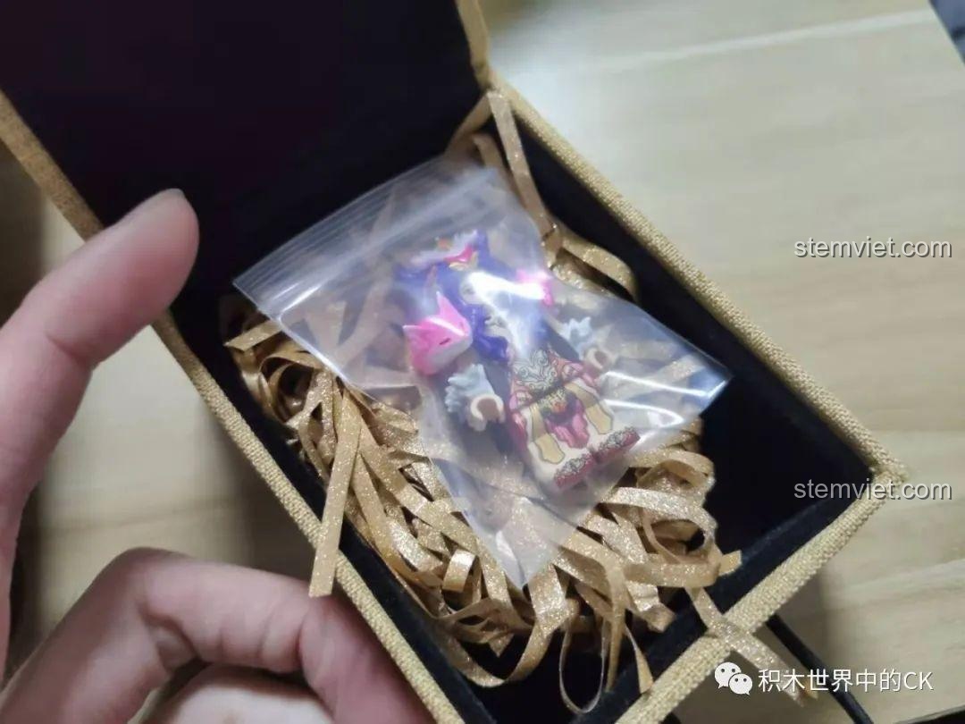 Hộp nhỏ màu vàng chứa túi mảnh ghép và giấy vụn trang trí, chuẩn bị cho trải nghiệm lắp ráp.