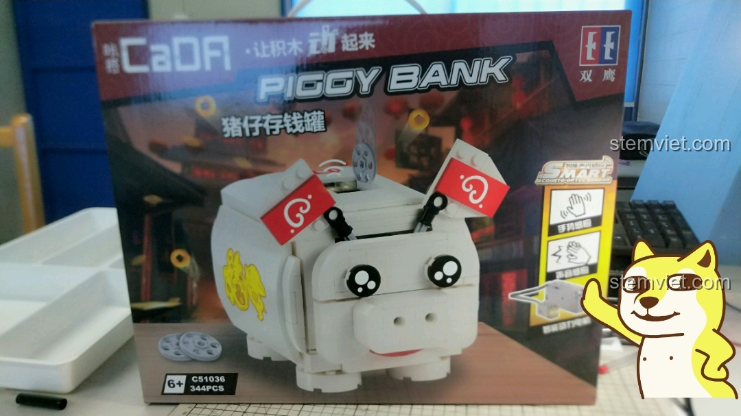 Hộp sản phẩm bộ lắp ráp CaDA C51036 Ống heo tiết kiệm thông minh, hiển thị hình ảnh chú heo trắng đáng yêu sau khi hoàn thành.