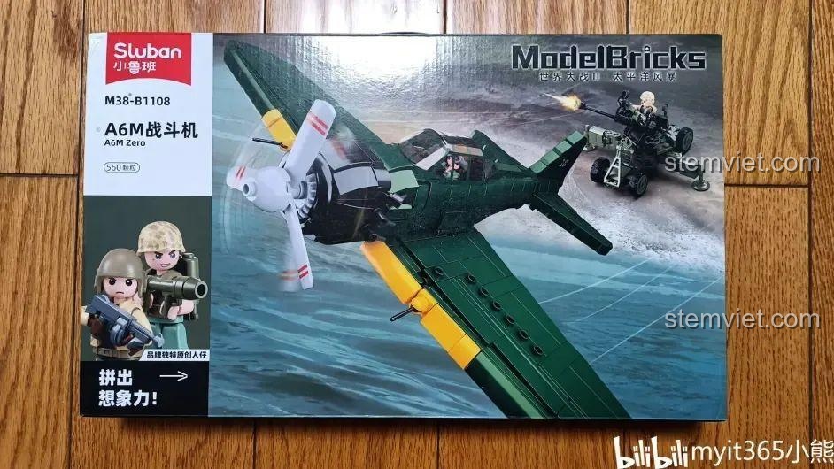 Hộp sản phẩm bộ lắp ráp Sluban M38-B1108 Tiêm kích hạm A6M Zero với hình ảnh máy bay và pháo cao xạ.