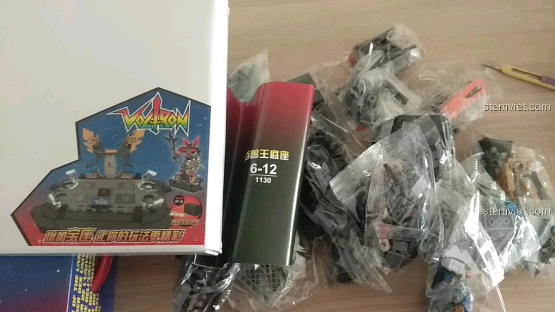 Sách hướng dẫn và các túi chi tiết của bộ lắp ráp Đế Trưng Bày Voltron Bách Thú Vương SY 1130 sẵn sàng để bắt đầu.