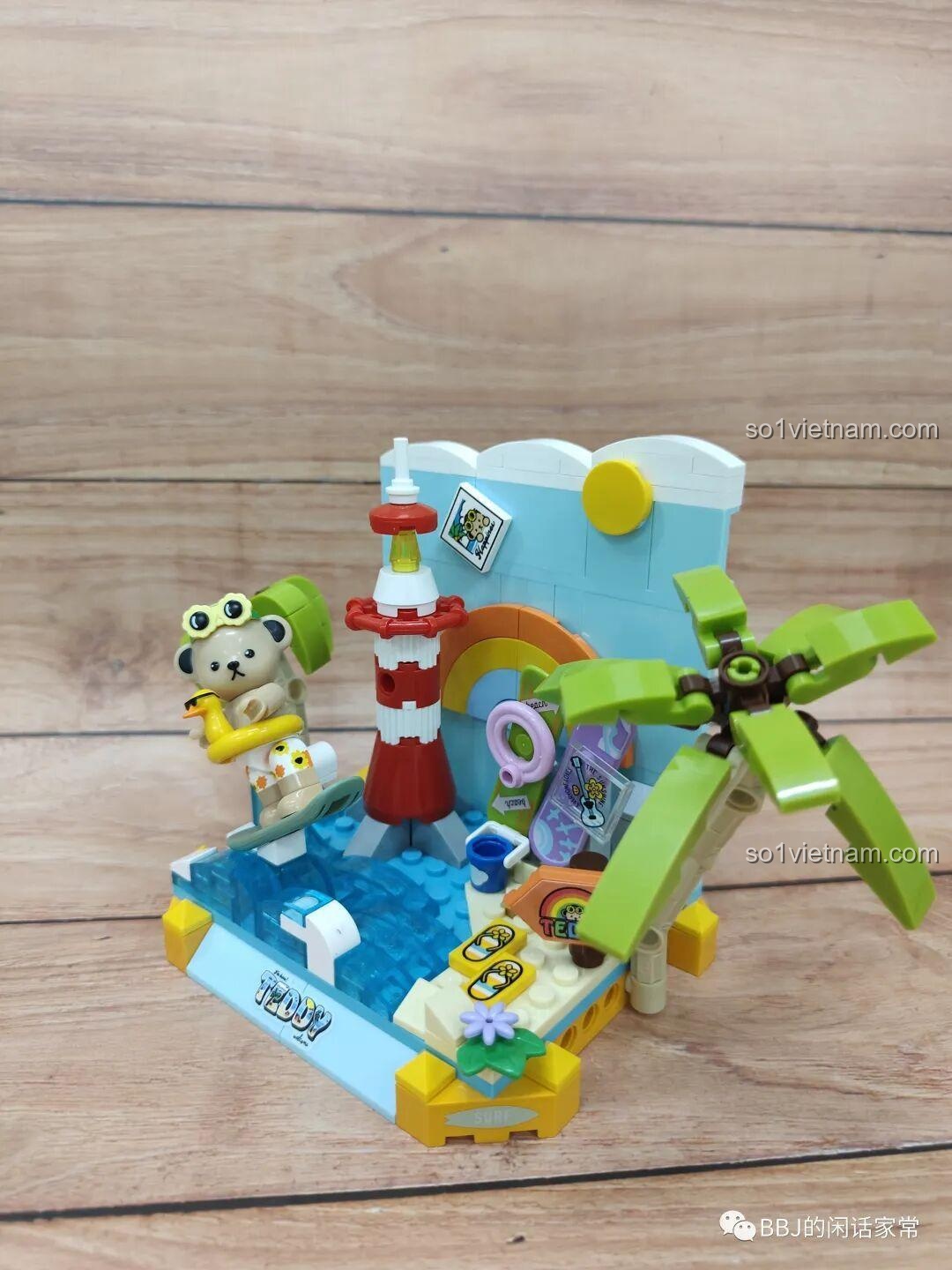 Toàn cảnh mô hình inbrixx 881007 Gấu Teddy Lướt Sóng Mùa Hè, với Gấu Teddy đang lướt sóng, ngọn hải đăng và cây dừa, tạo nên một khung cảnh biển sống động.