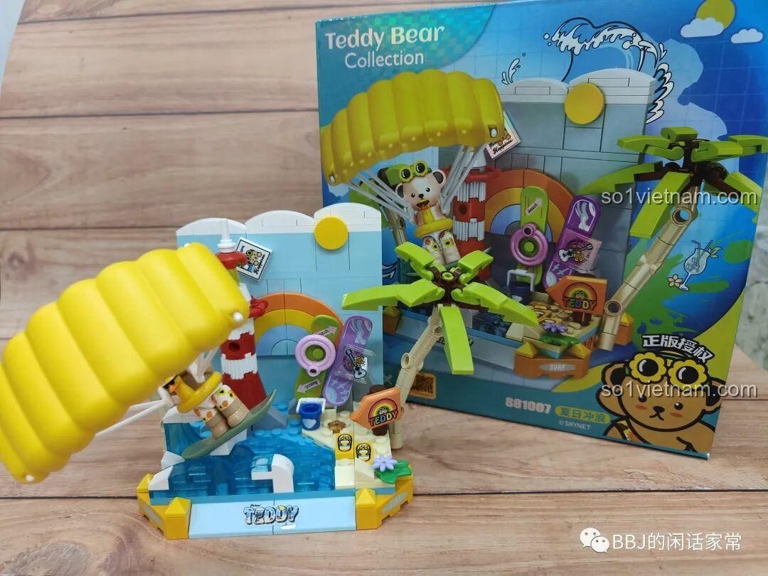 Gấu Teddy với dù bay và cây dừa trong mô hình inbrixx 881007 Gấu Teddy Lướt Sóng Mùa Hè, tạo nên một khung cảnh tổng thể hài hòa và đầy màu sắc.