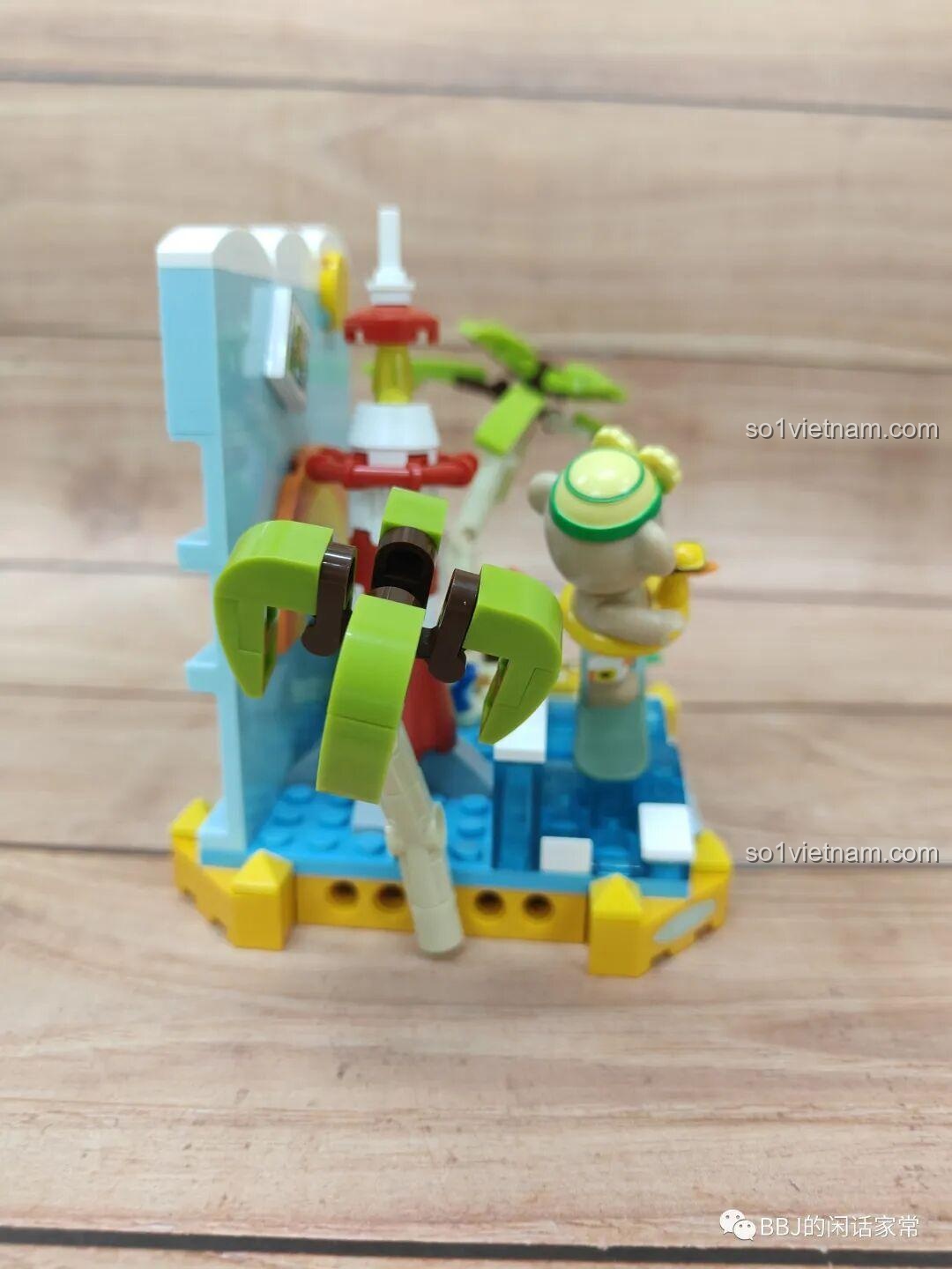 Góc nhìn từ phía sau của mô hình inbrixx 881007 Gấu Teddy Lướt Sóng Mùa Hè, tập trung vào cây dừa và ngọn hải đăng, thể hiện sự cân đối của thiết kế.