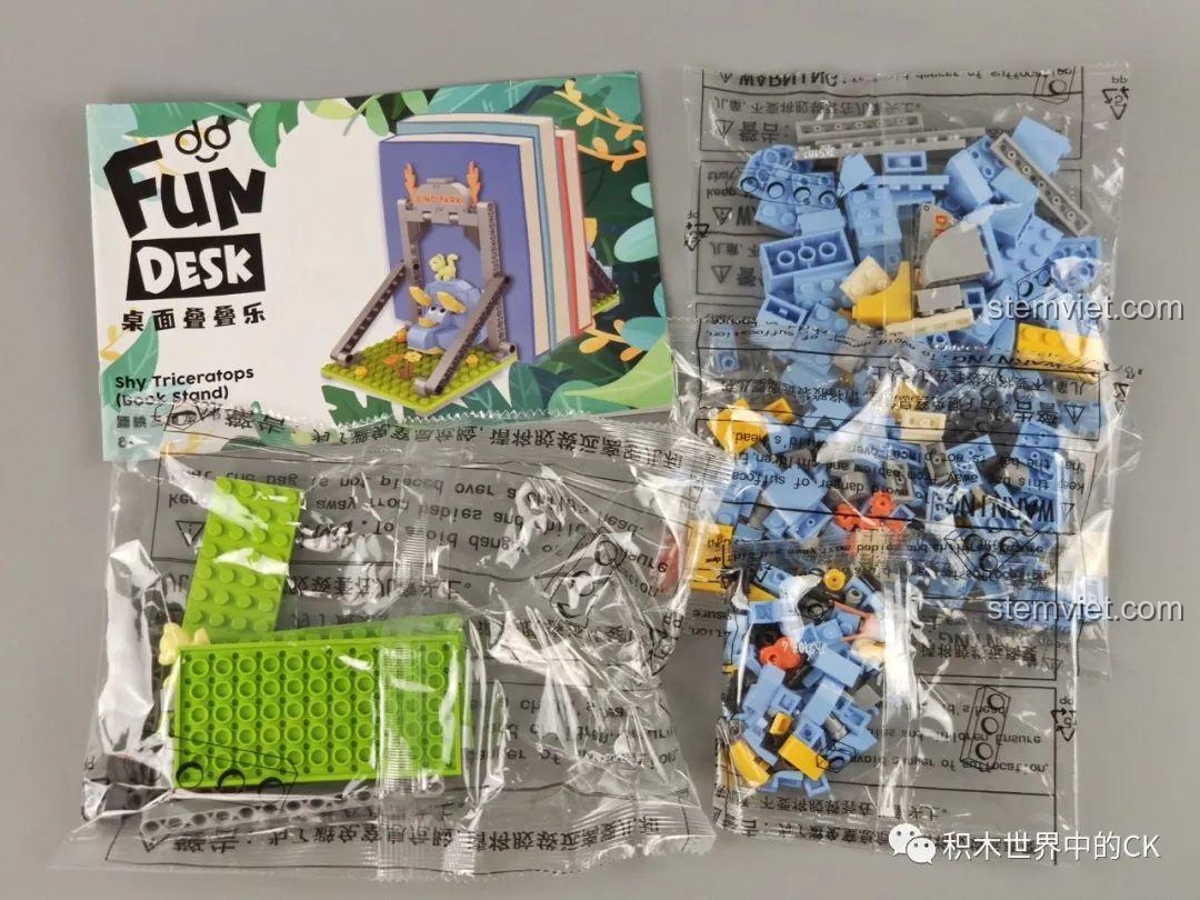 Mô hình giá đỡ sách khủng long ba sừng JAKI Fun Desk đã lắp ráp hoàn chỉnh, với cổng Dino Park và chú mèo con đáng yêu.