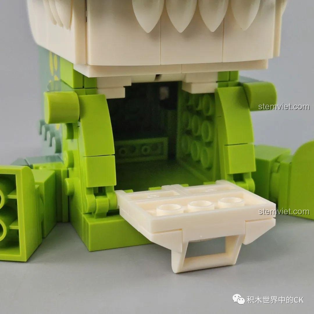 Ảnh unboxing bộ đồ chơi lắp ráp giá đỡ sách khủng long ba sừng JAKI Fun Desk, hiển thị các túi mảnh ghép và sách hướng dẫn.