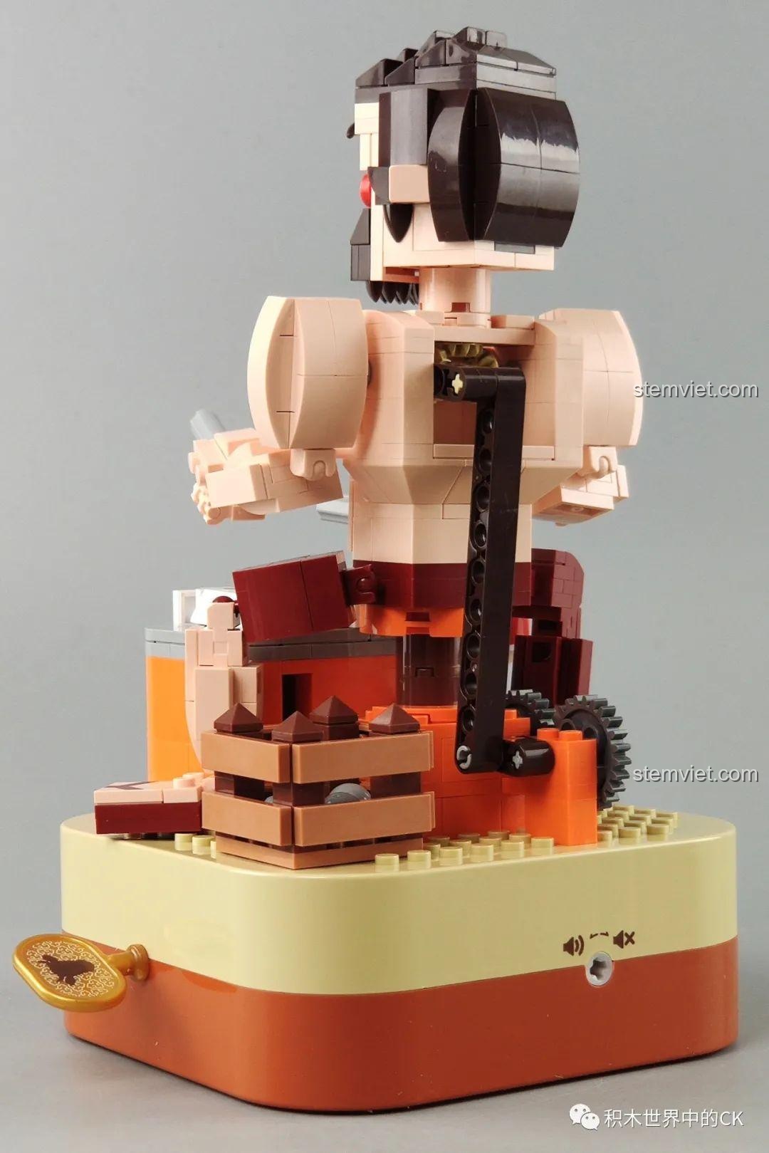 Mặt sau của mô hình Hộp nhạc thịt bò viên JAKI JK1801, hiển thị cơ chế bánh răng và cần gạt điều khiển.