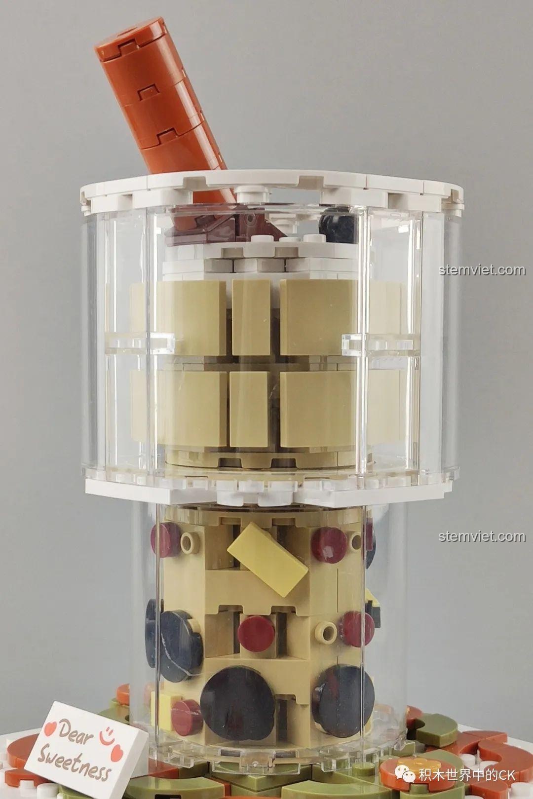 Mô hình Hộp nhạc trà sữa JAKI nhìn từ góc nghiêng, thể hiện cấu trúc nhiều tầng và các chi tiết bên trong ly.