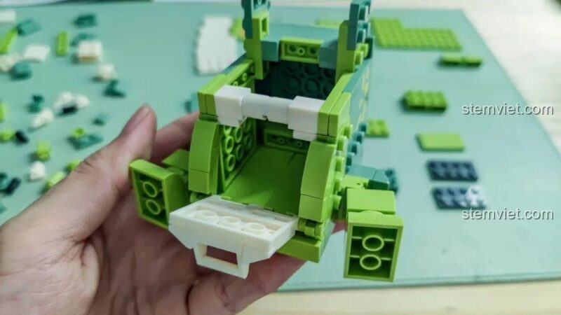 Bên trong mô hình Khủng long T-Rex hộp bút JAKI JK5102 đang lắp ráp, cho thấy không gian chứa đồ.