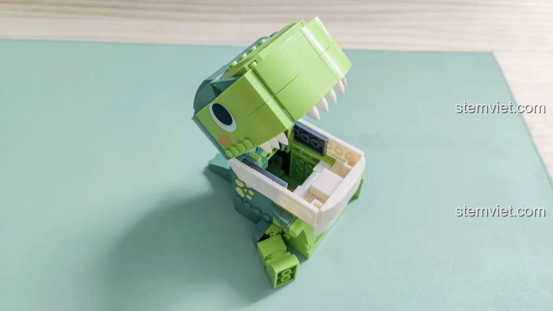 Cận cảnh miệng mở của Khủng long T-Rex hộp bút JAKI JK5102, lộ rõ không gian chứa đồ và răng nanh trắng.
