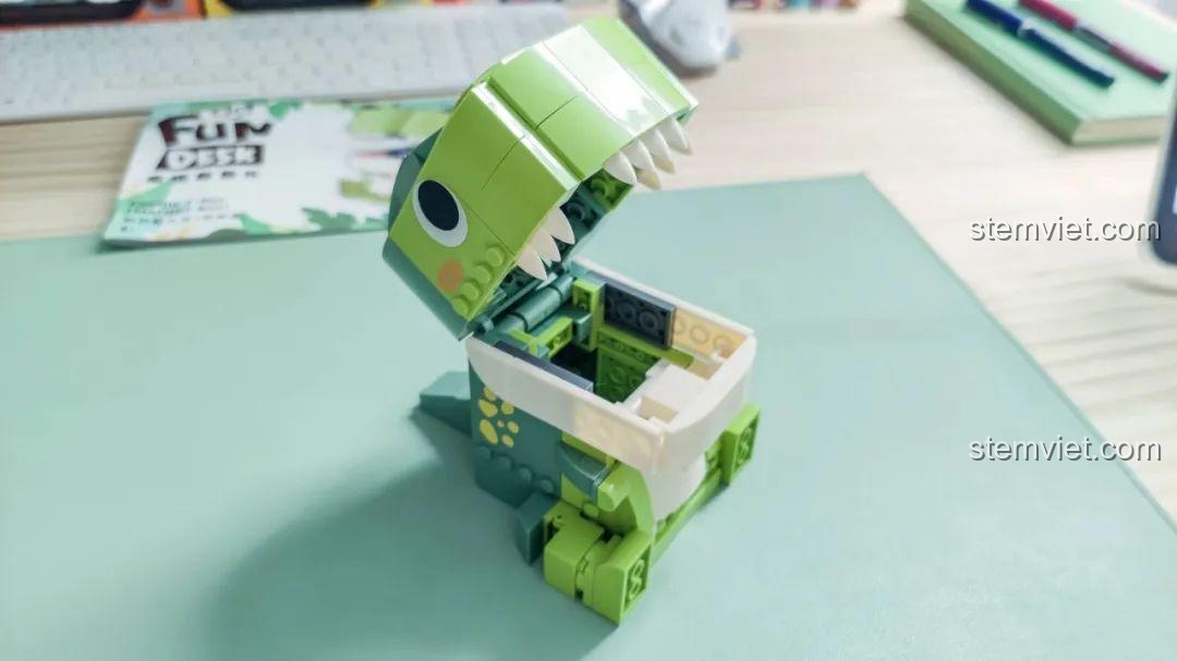 Mô hình Khủng long T-Rex đa năng JAKI JK5102 với miệng mở, sẵn sàng đựng các vật dụng nhỏ, đồ chơi sáng tạo.
